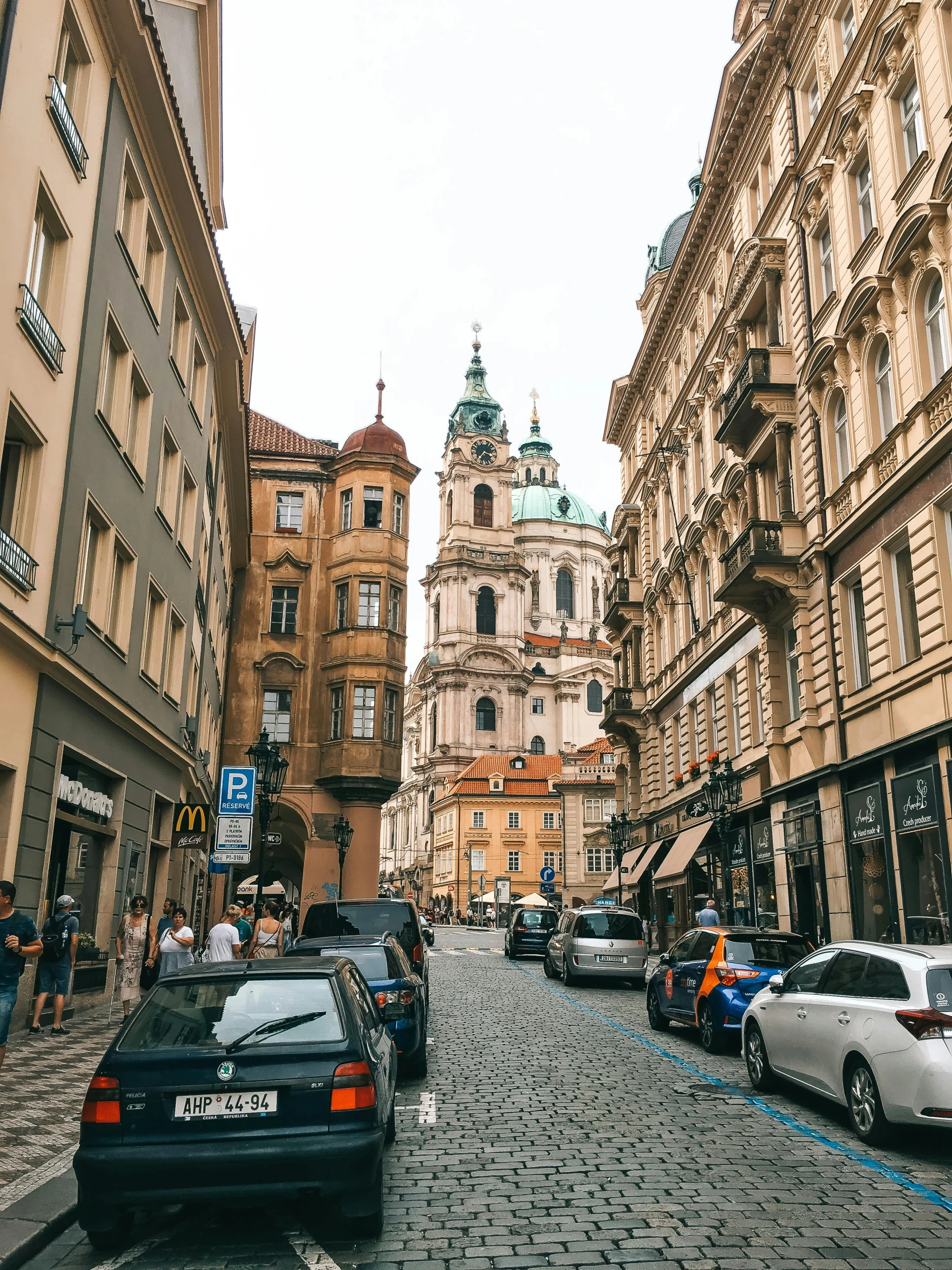 a city street lined with tall buildings and parked cars