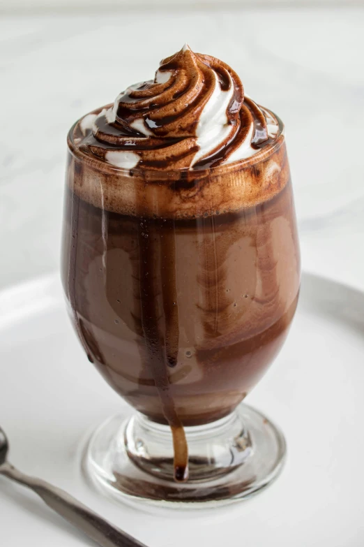 a glass of beverage with whipped cream and chocolate