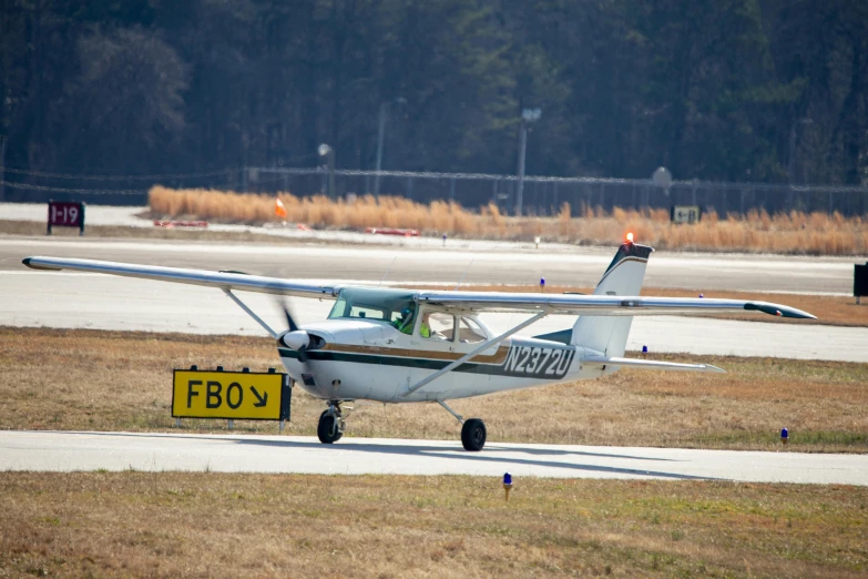 a white small airplane is about to take off from an airport