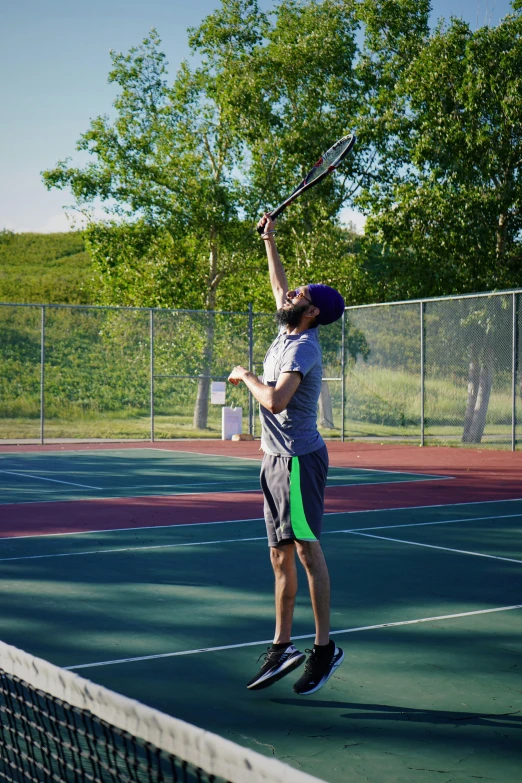 man standing on tennis court getting ready to serve