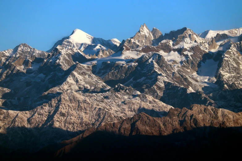 the high mountains are covered in snow against a bright blue sky