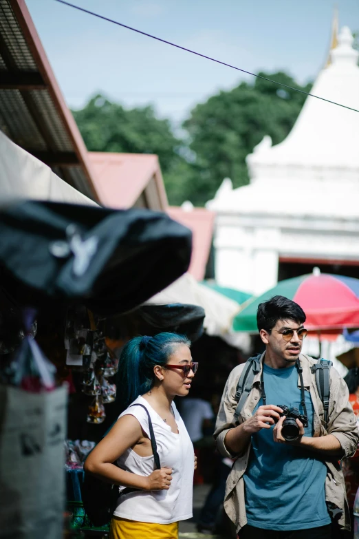 a woman in blue hair and man with camera