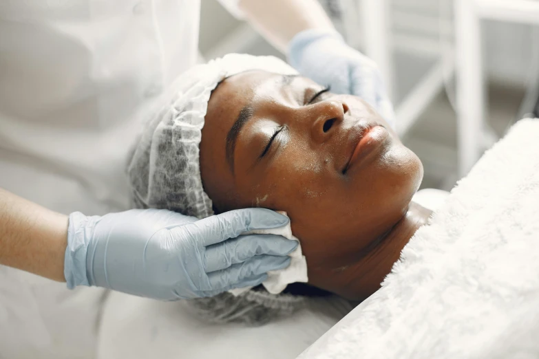 a woman is laying on a bed getting facial scrub