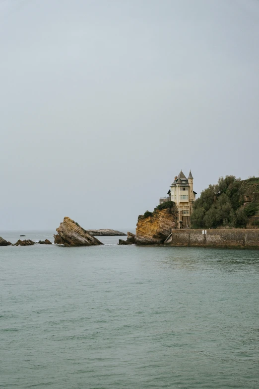 a large house by some water near rocks