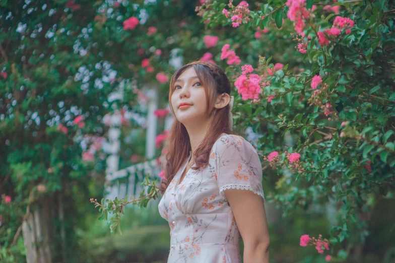 woman standing in front of trees with pink flowers