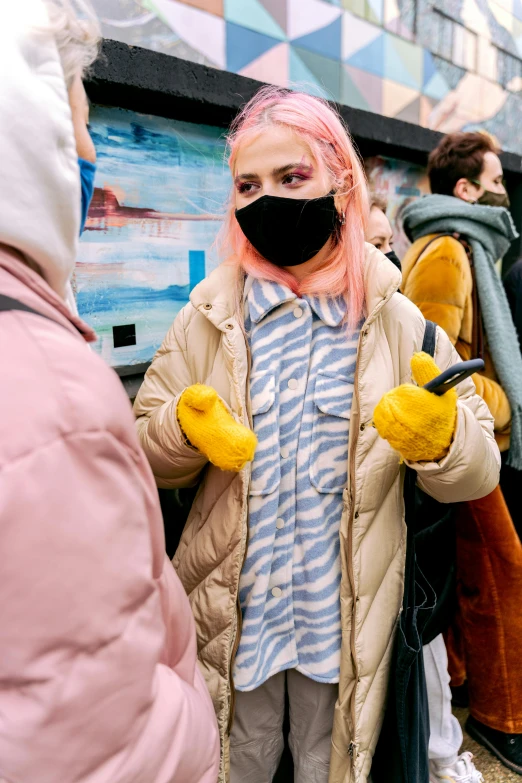 a person in a black face mask and yellow gloves