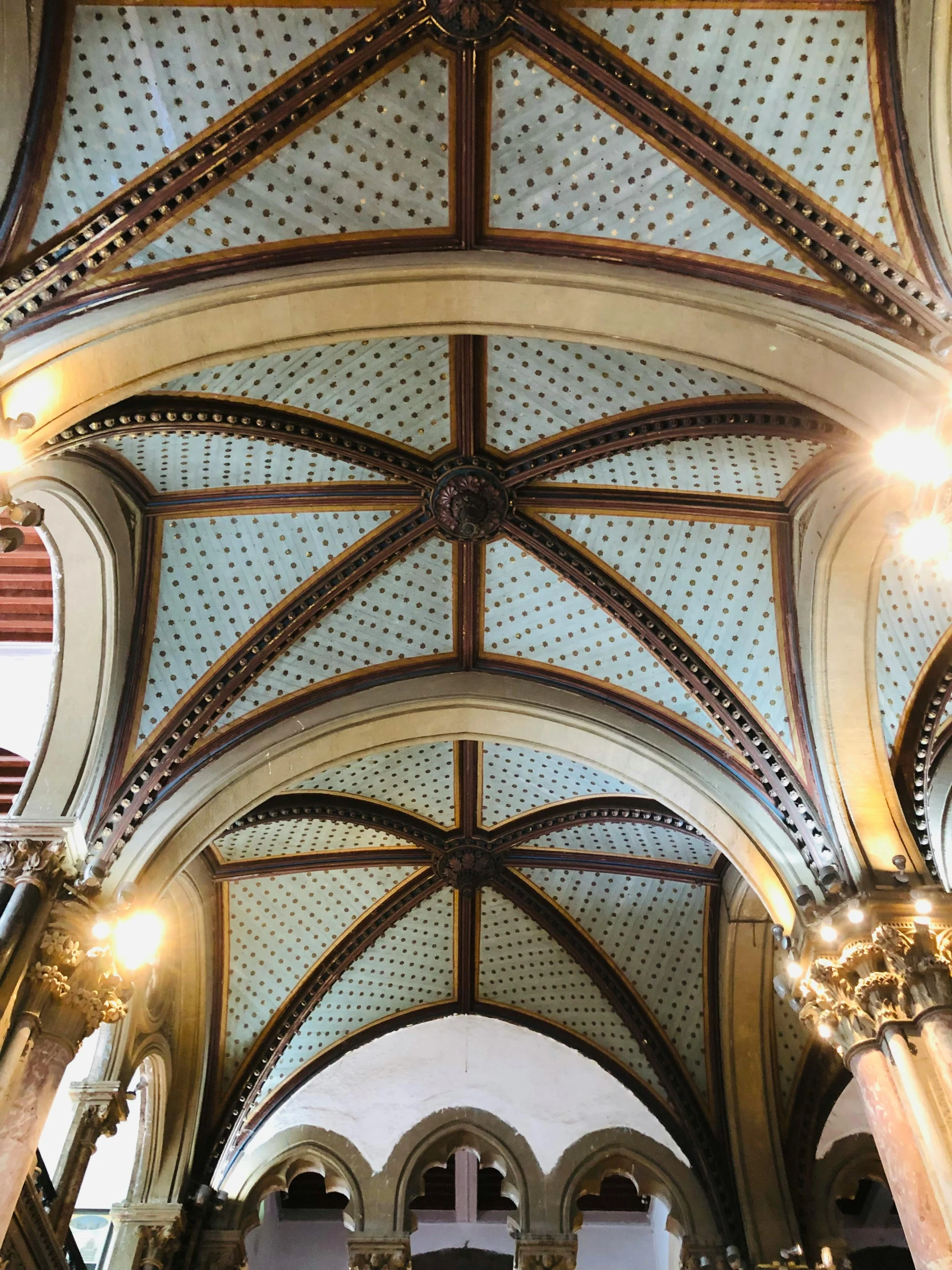 view looking up at ornate vaulted ceiling and pillars