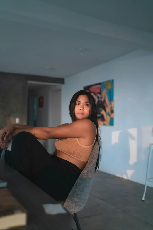 woman posing on a wall in front of a painting