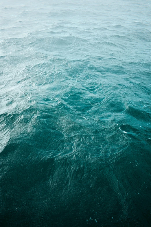 a man riding a small wave in the ocean on a board