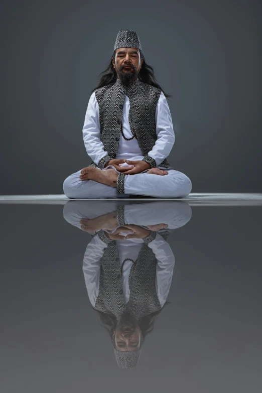 the man is practicing yoga with his reflection in water