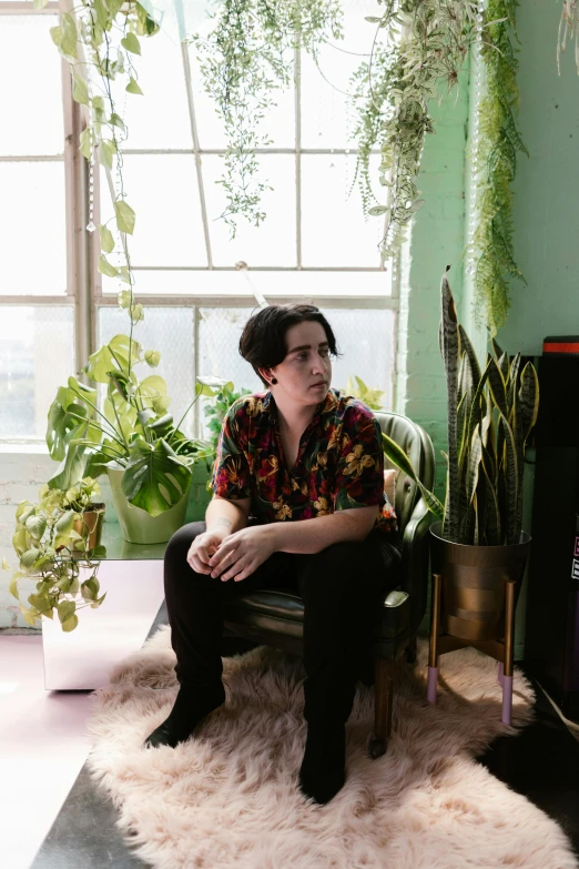 a person sitting on a couch near some plants