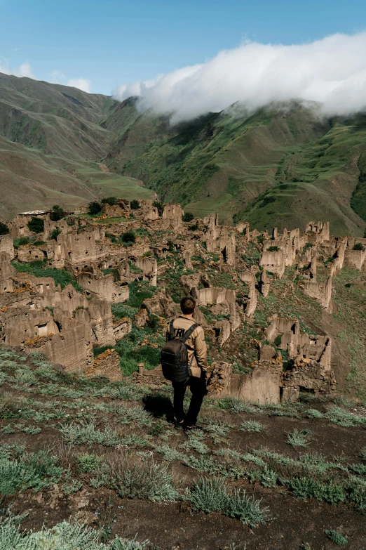 a person hiking up a mountain covered in green grass