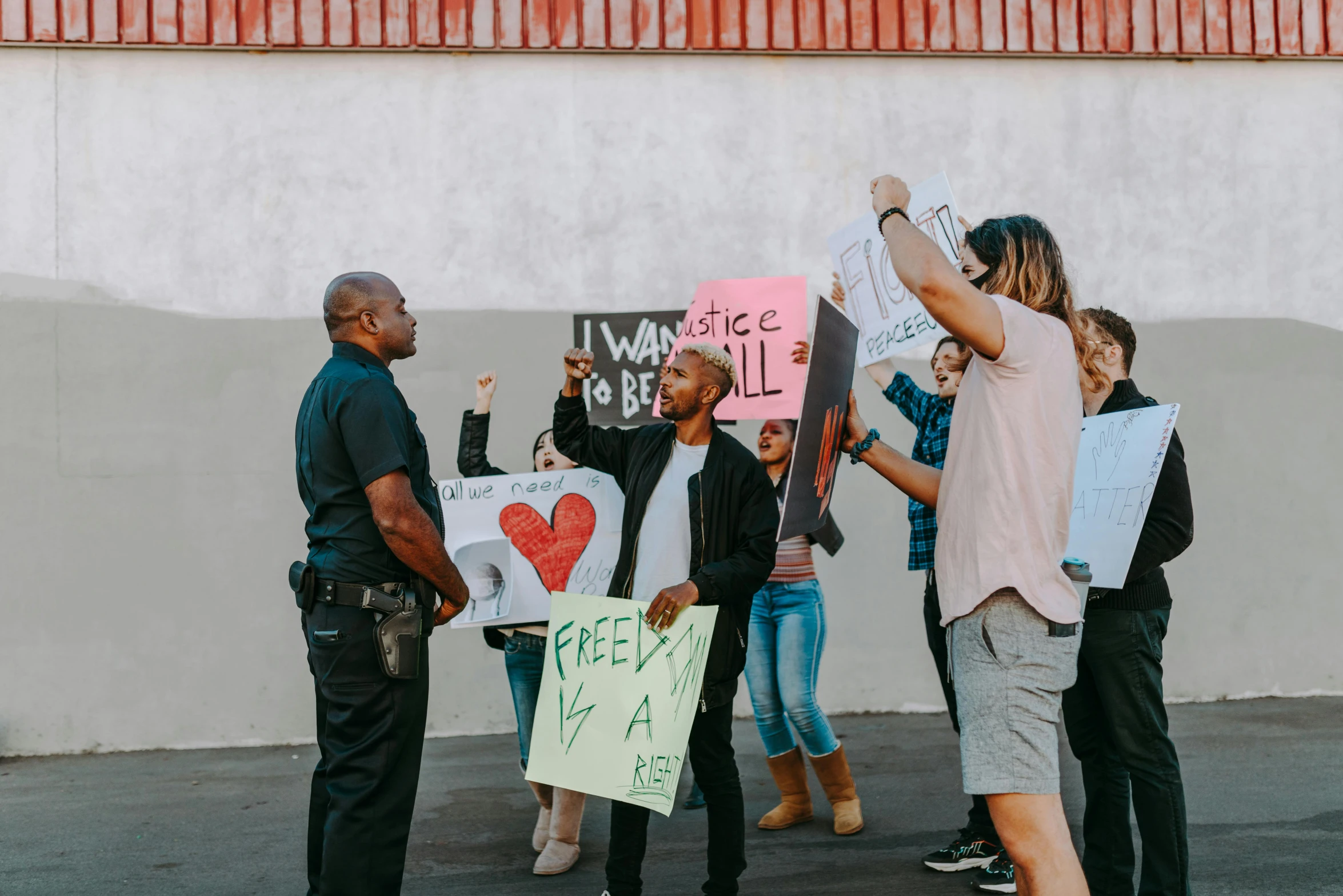 people standing outside holding signs and a police officer