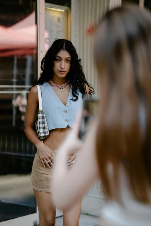 woman looking at her reflection in the mirror while holding her camera up