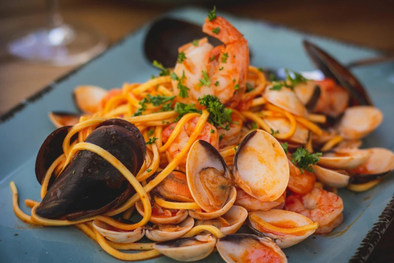 pasta and seafood is on a blue plate