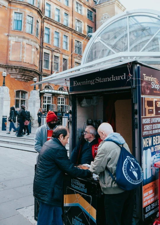 a group of people standing around a kiosk