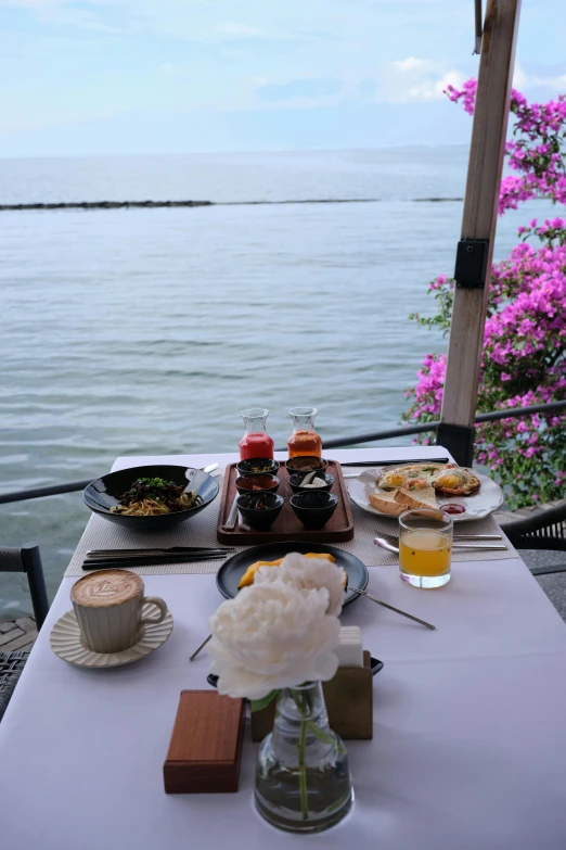 the table is set up with breakfast at the lake