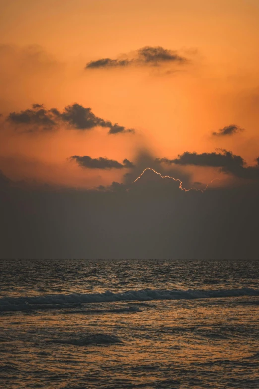 sunset in po of distant light above calm ocean waters