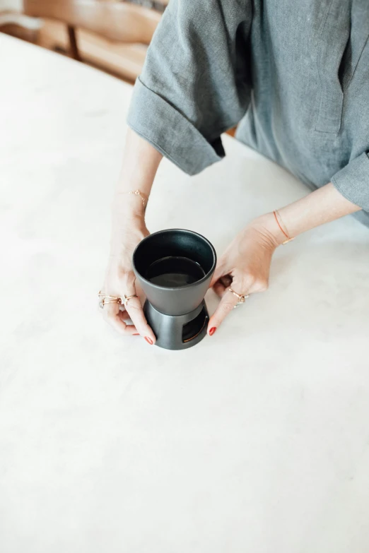 a woman with her hands over the top of a cup