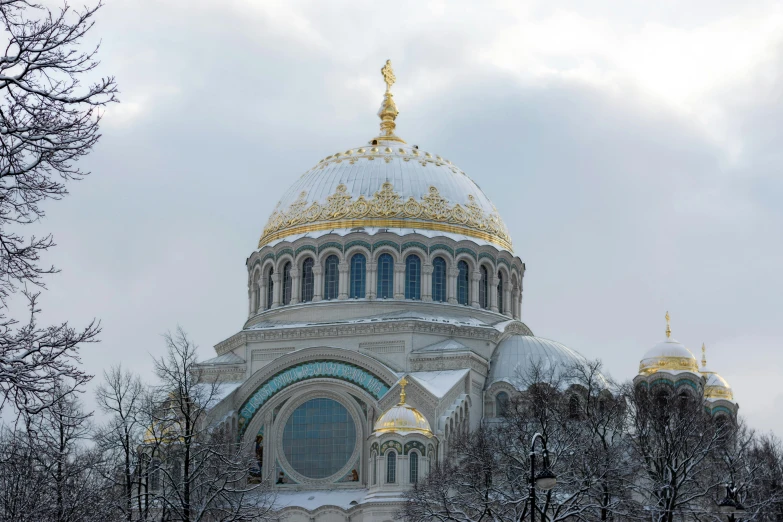 an ornate dome structure of a building is covered in snow