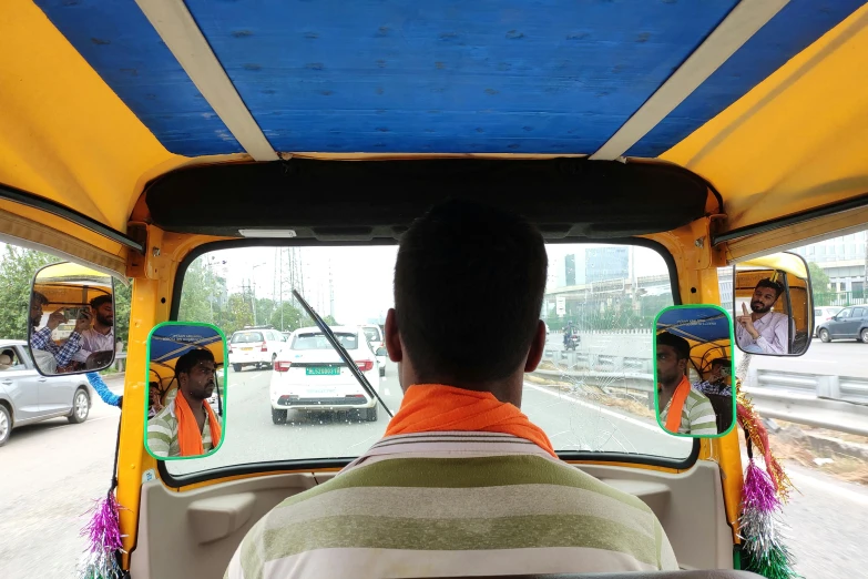 a man driving a taxi in traffic and looking out the window