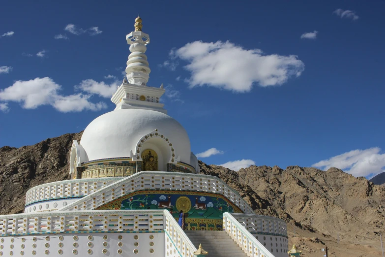 a large white building with a golden dome and a stairway