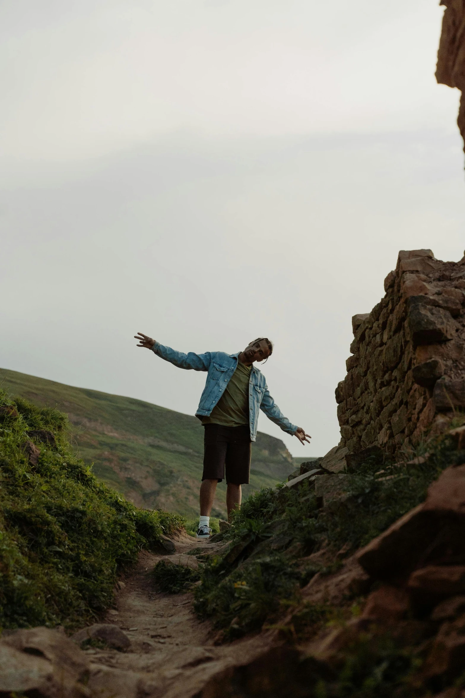 a person who is reaching for the sky on a mountain