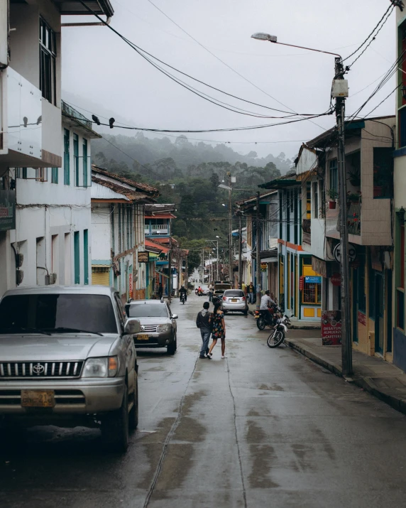 two people walking down the street of an old town