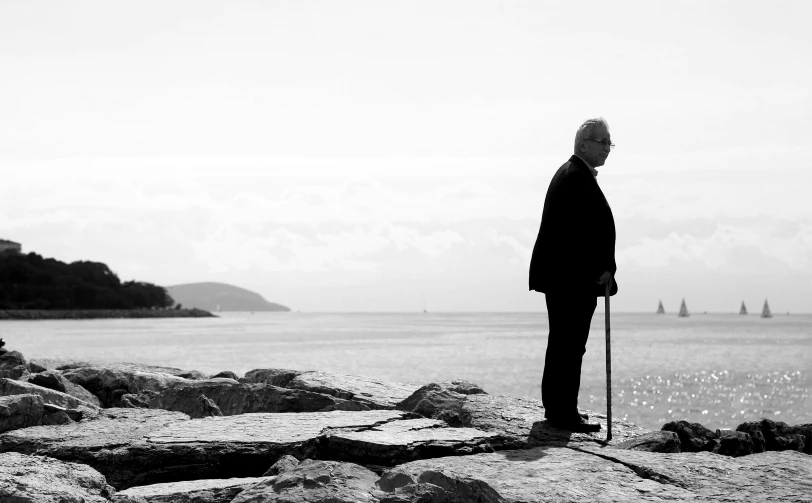 a man standing on a rock face to head overlooking the ocean