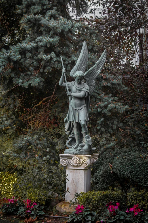 statue of an angel with two arrows near trees