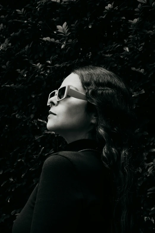 a woman with long hair wearing sunglasses and a black shirt