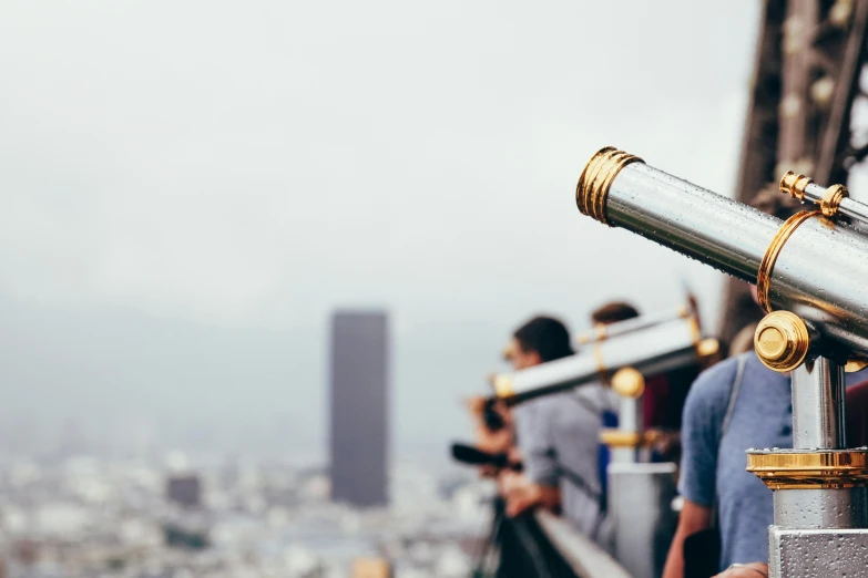 two people at the top of a building looking over the city