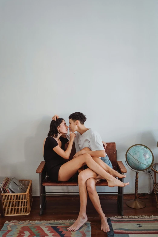 a man kissing his beautiful wife while sitting on her lap