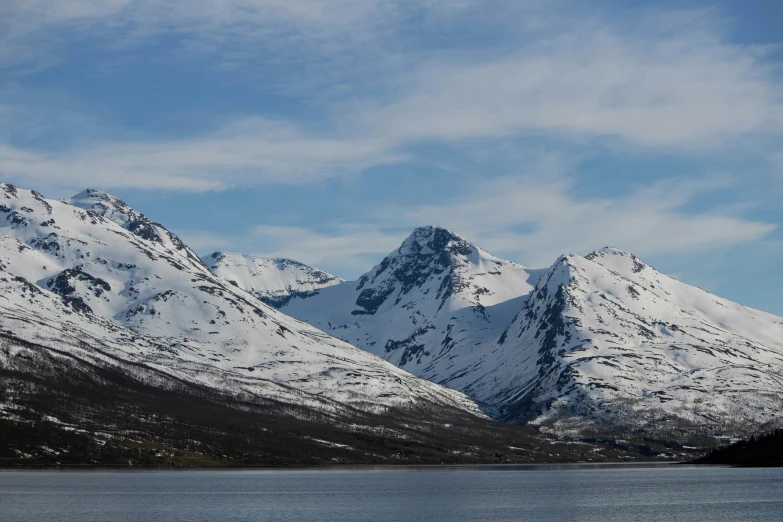 mountains are covered in snow and blue water