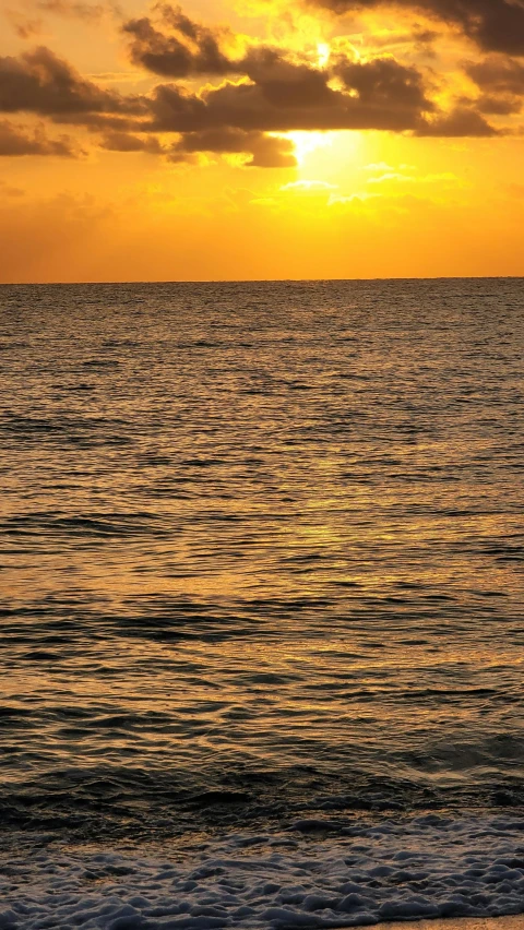 the sun is setting over the ocean at beach