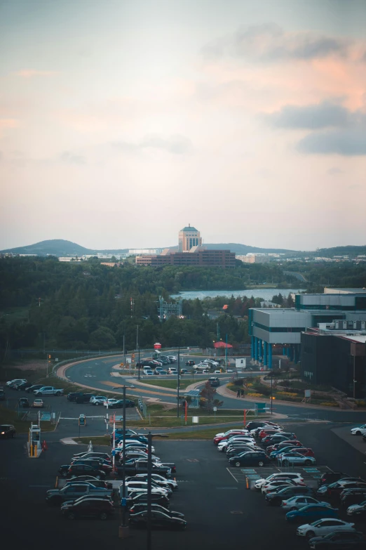 a parking lot filled with parked cars near a tall building