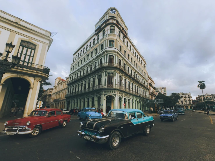 cars on a city street in front of old buildings