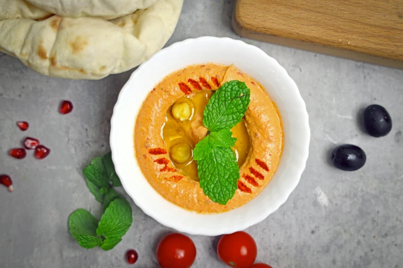 a small bowl is adorned with a green leaf and a vegetable garnish