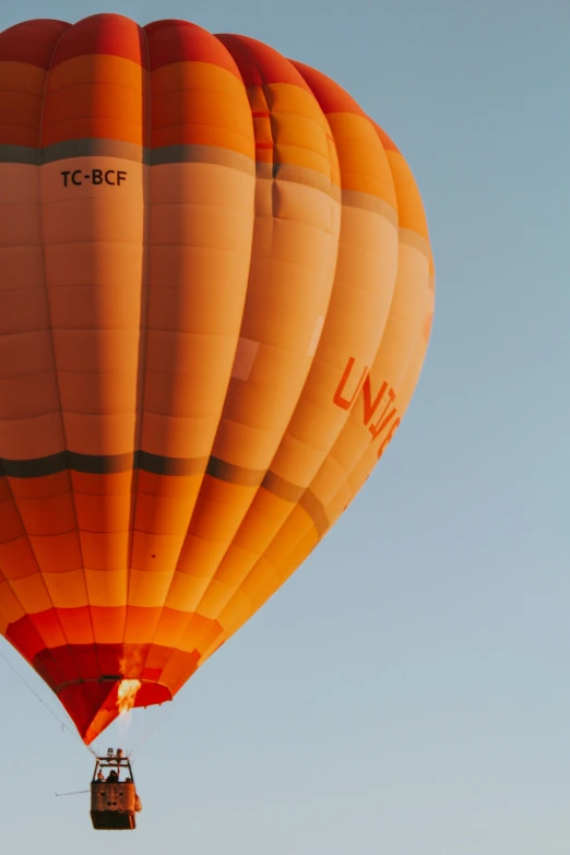 a very large yellow  air balloon flying through the sky