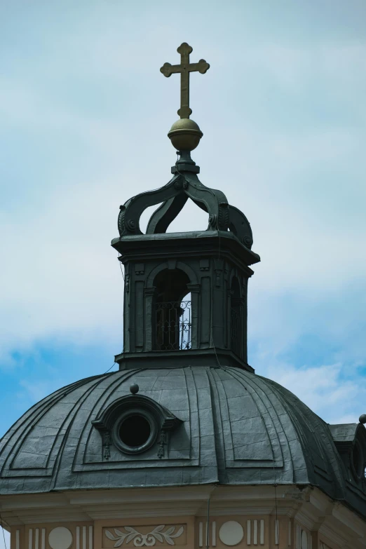 a view of an ornate roof with a cross on top