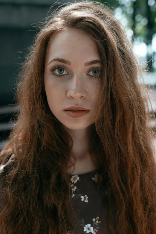 a woman with long brown hair is looking at the camera