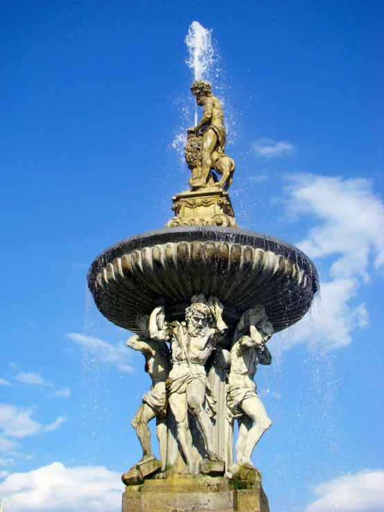 the fountain has statues on it in the water