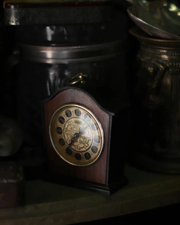 small clock with large hands sits on display in the dark