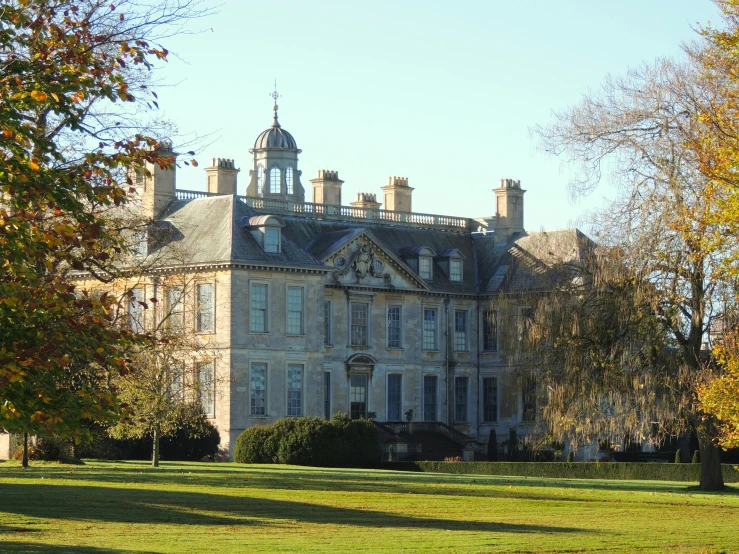 an old style house with two towers stands in the grass