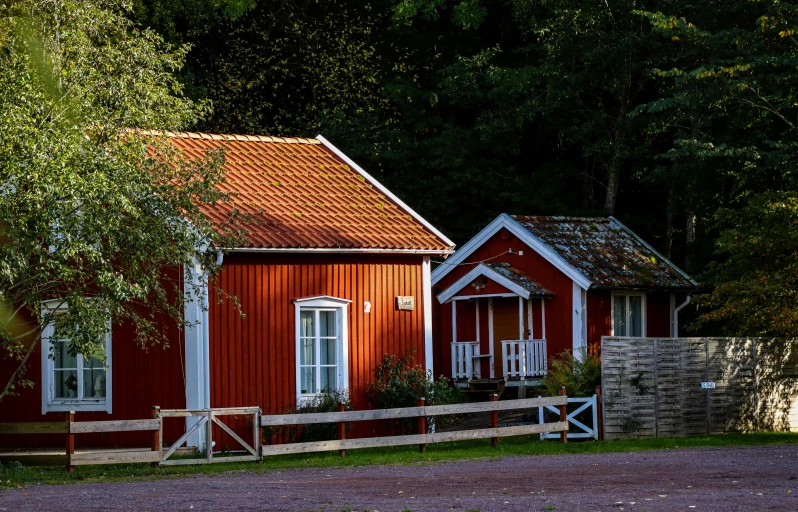 a red house on the side of a dirt road