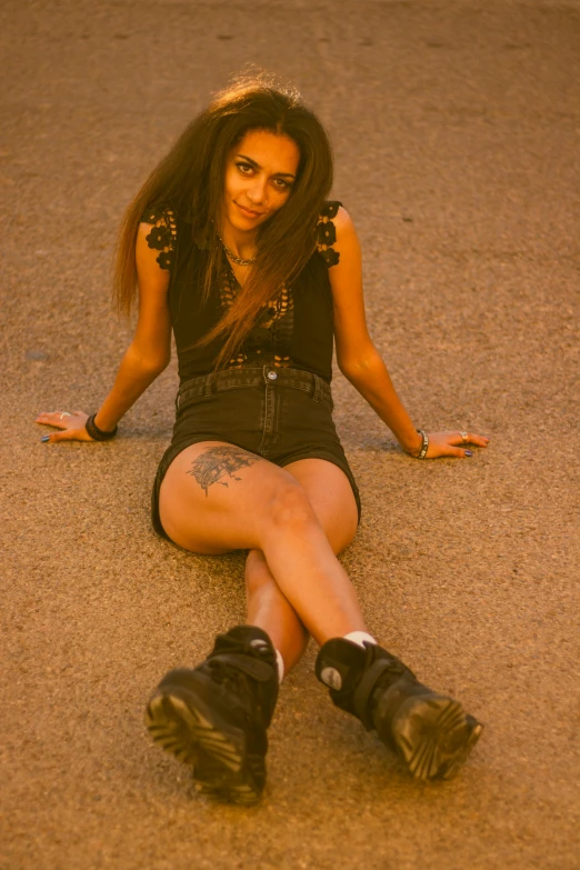 a young woman sitting on the ground with a pair of black shoes