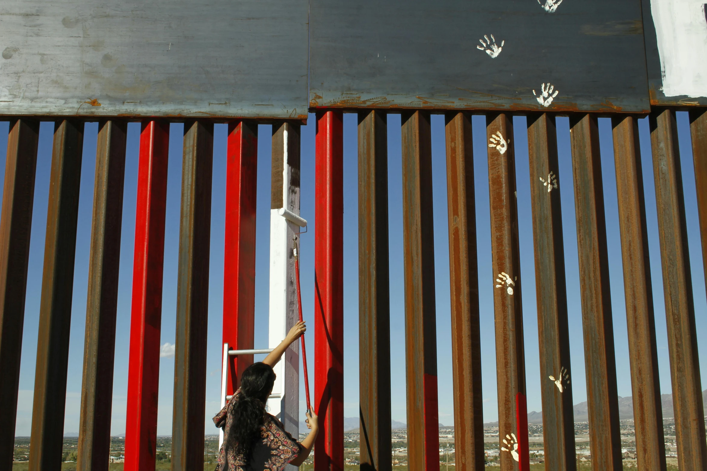 a woman hanging onto a red striped fence