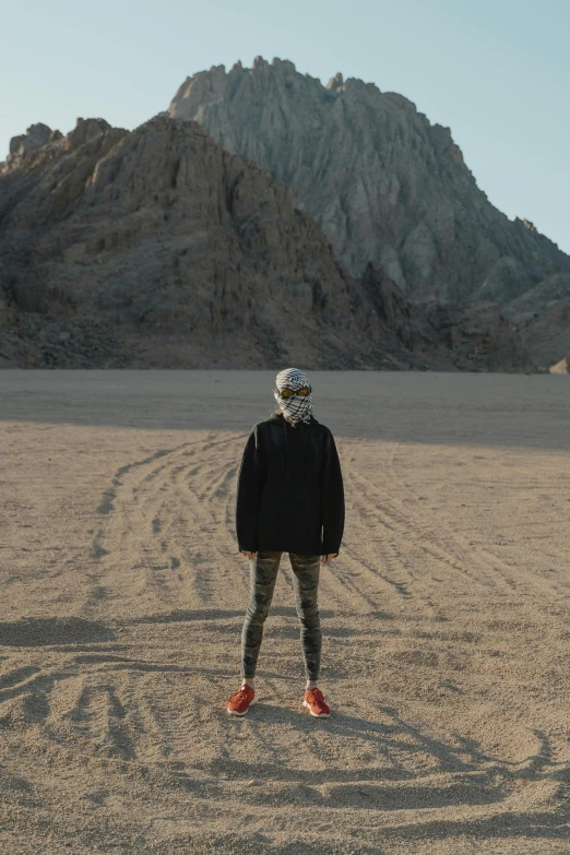 man standing in a desert with mountains in the background