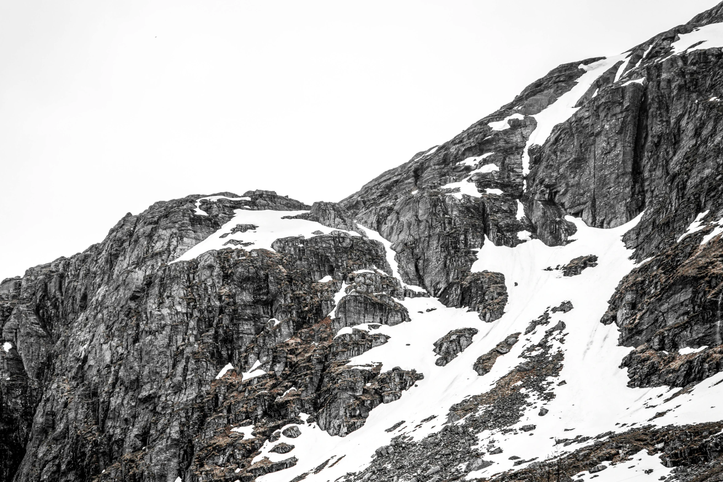 a snowy mountain side with a large peak in the distance