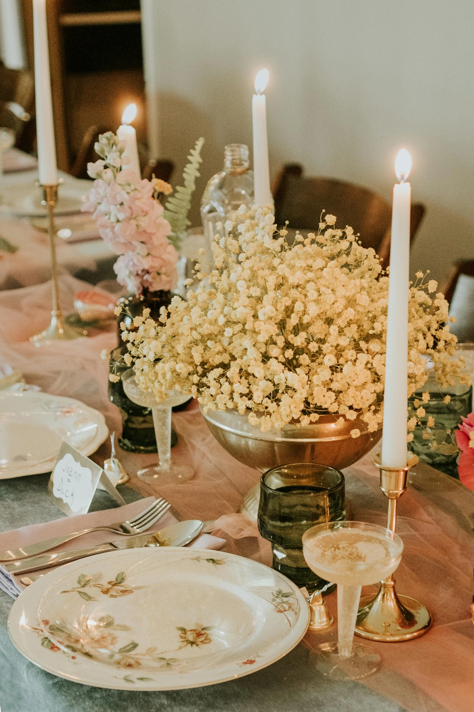 table set with flowers and candles on plates